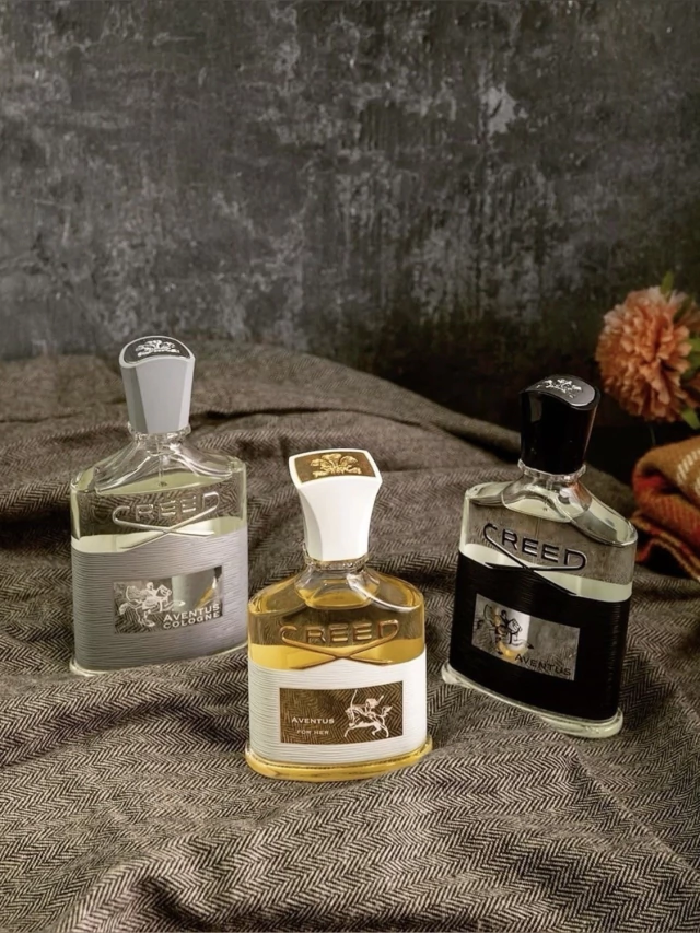 Trio de perfumes de nicho sobre tecido em fundo escuro